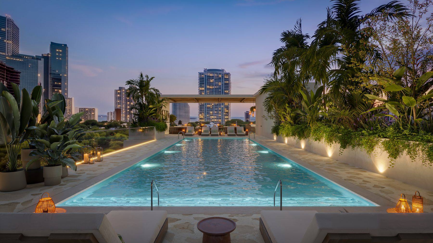 Rooftop pool deck at night, lit cabanas and loungers
